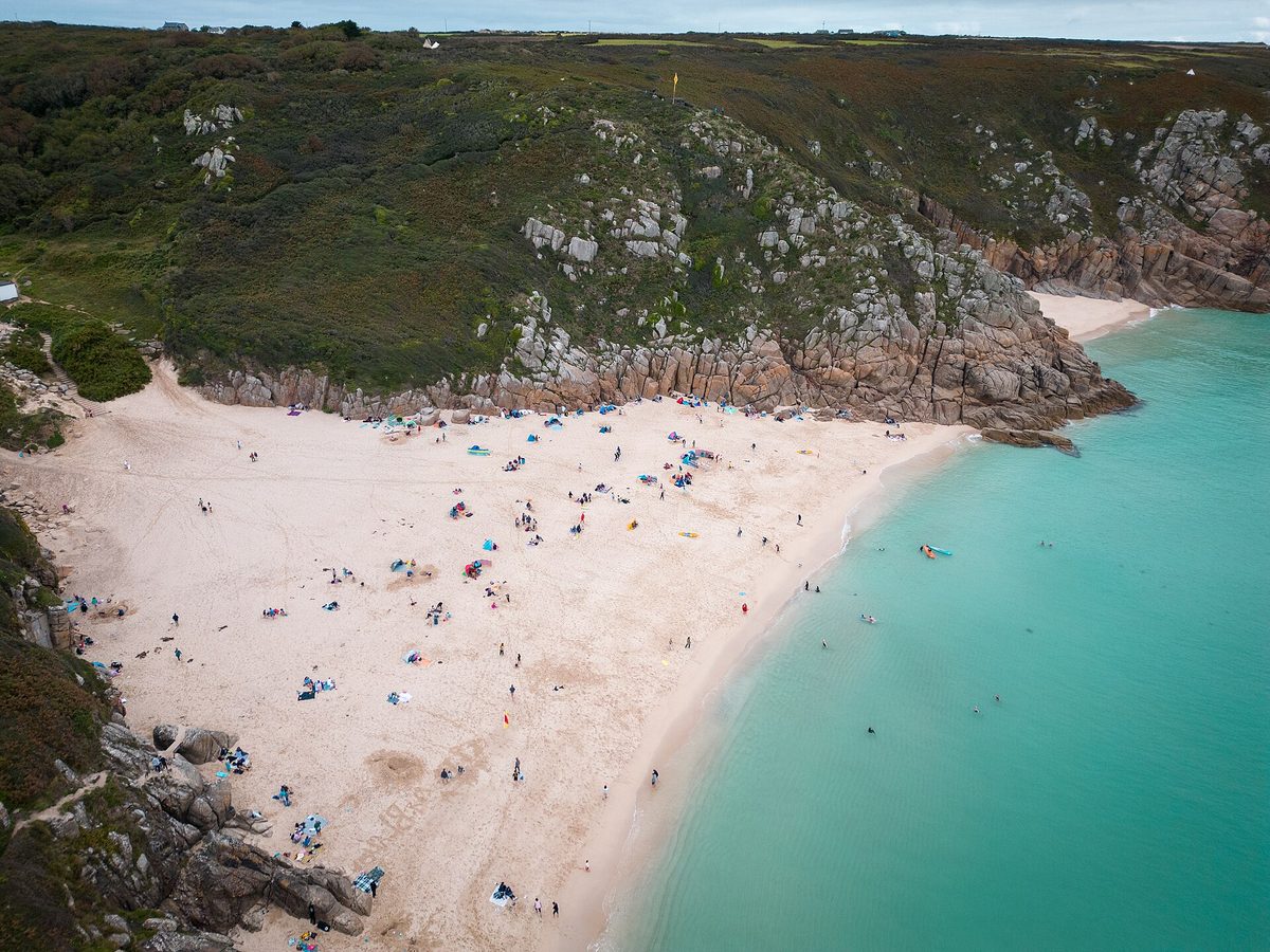 White sand and turquoise water at Porthcurno beach beneath dramatic cliffs in Cornwall