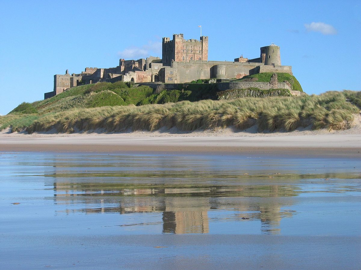 Bamburgh Castle on its basalt crag above the Northumberland coast at golden hour