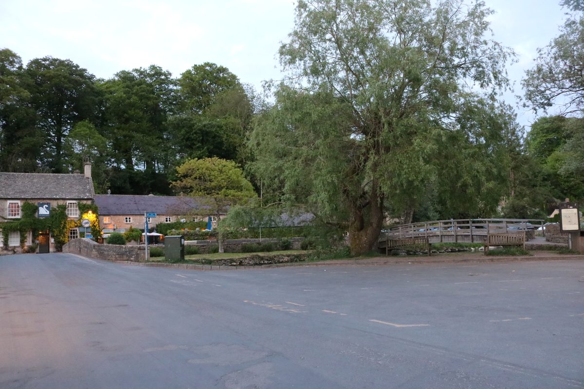 A Cotswolds village street with stone cottages and a small bridge