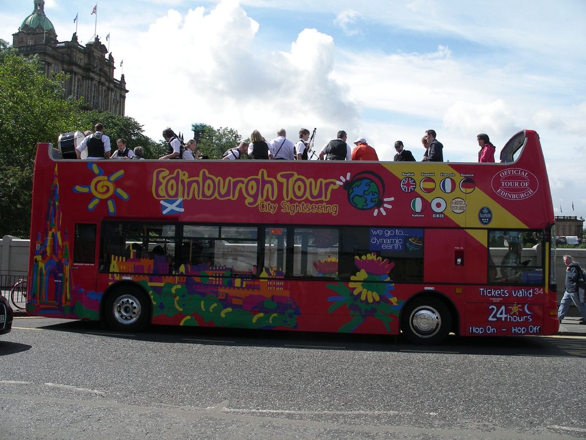 An open-top sightseeing bus near Stonehenge, using England coach travel as a transport hack