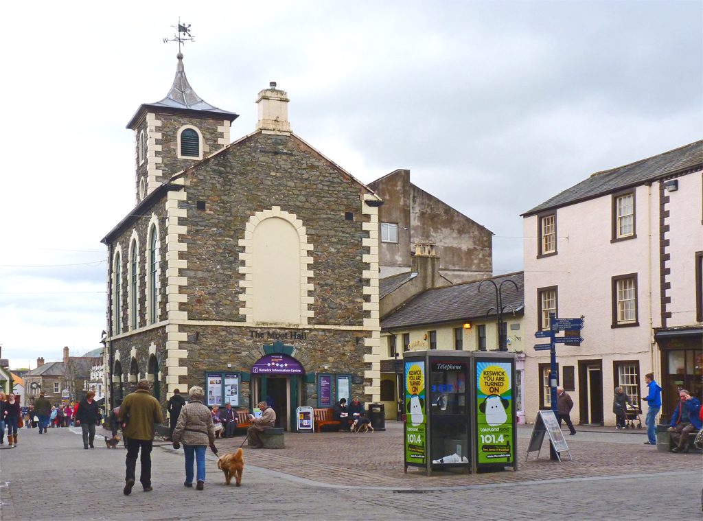 The historic Moot Hall in Keswick's market square with its one-handed clock and outdoor shops behind