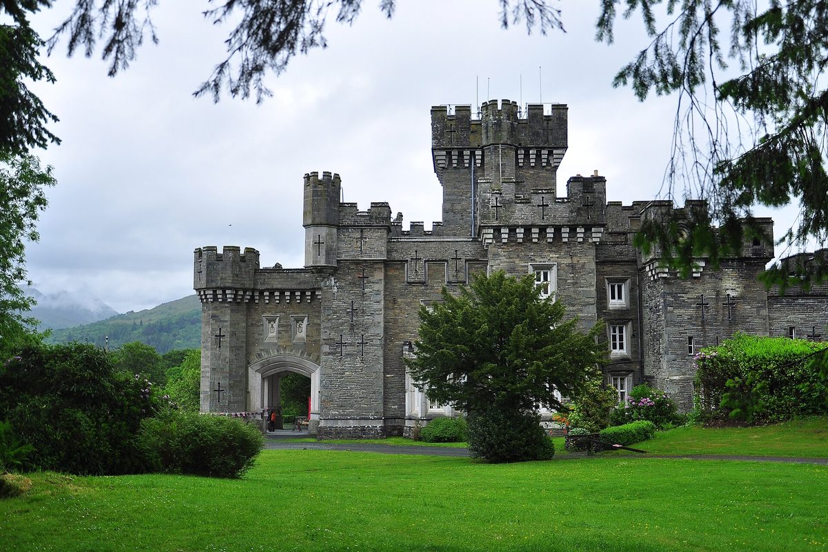 The neo-Gothic turrets of Wray Castle rising above trees on the quiet western shore of Lake Windermere